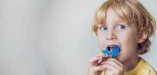 little boy playing with mouthguard after dental treatment 2