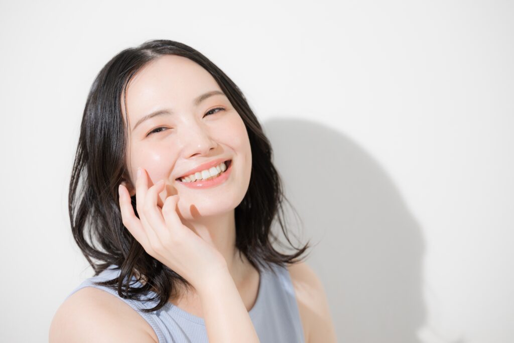 attractive young woman with healthy smile shows the benefits of using end-of-year dental benefits before they expire